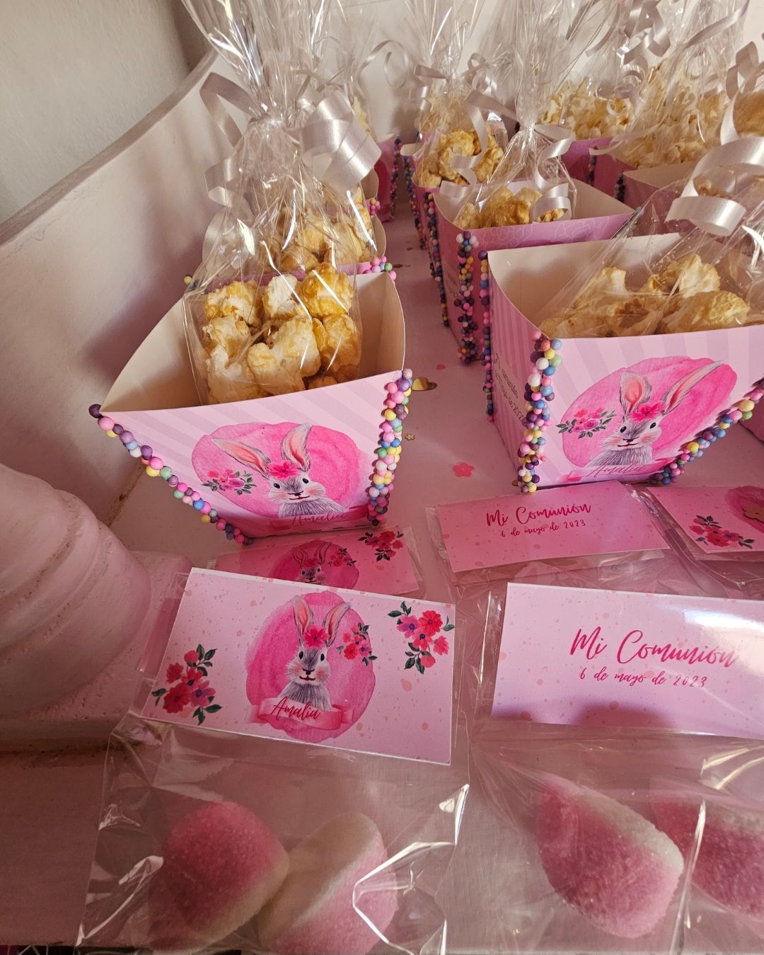 Un montón de cajas rosas llenas de palomitas de maíz y dulces.