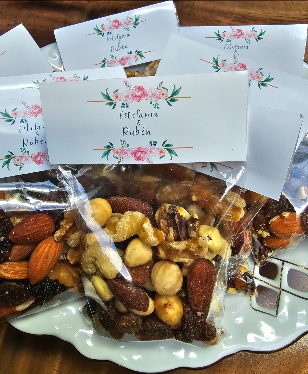 Un plato blanco cubierto con nueces y un cartel que dice felicitaciones