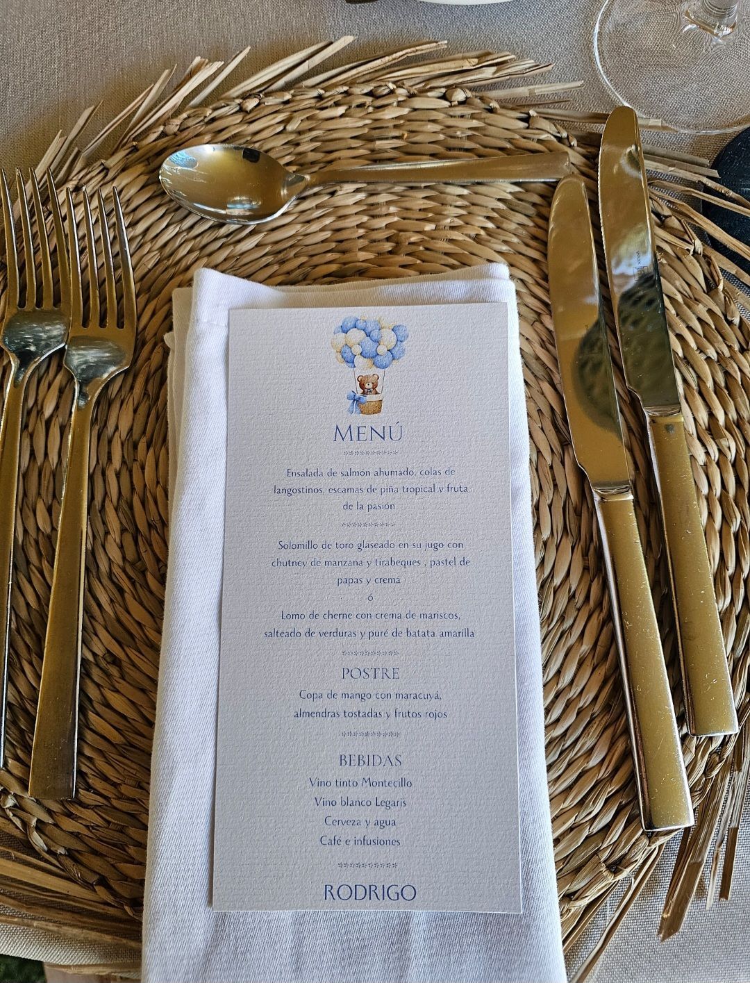 Un menú está sobre una servilleta sobre una mesa con cubiertos.