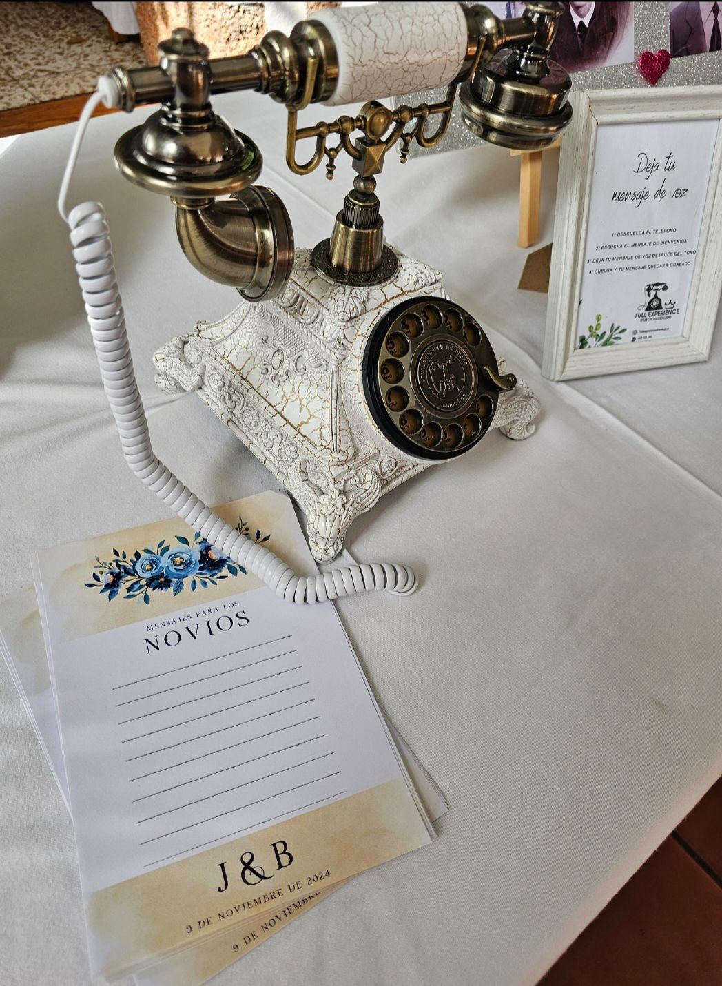 Hay un teléfono antiguo sobre una mesa al lado de un cartel que dice J & B.