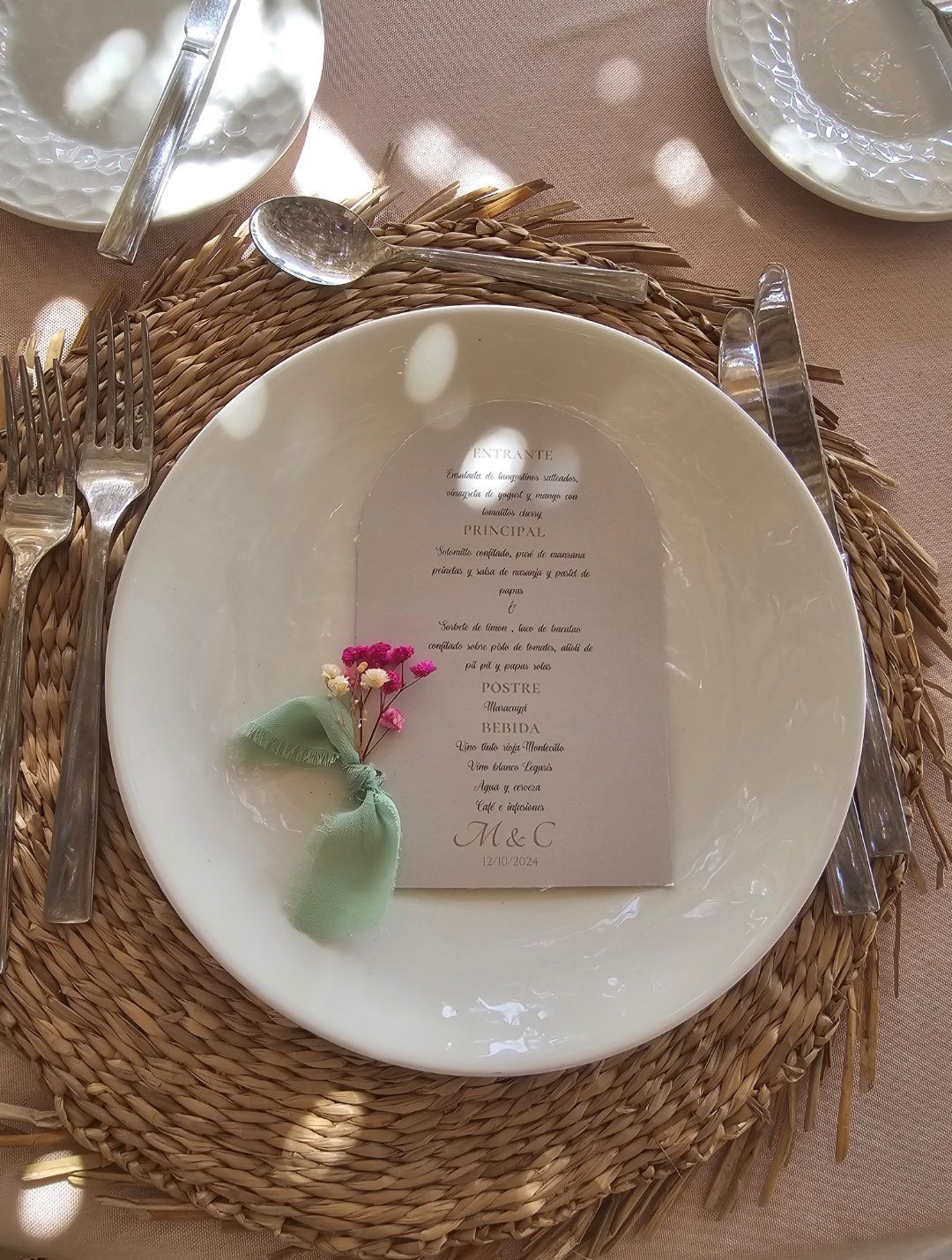 Un plato blanco con un menú está sobre un mantel de mimbre.