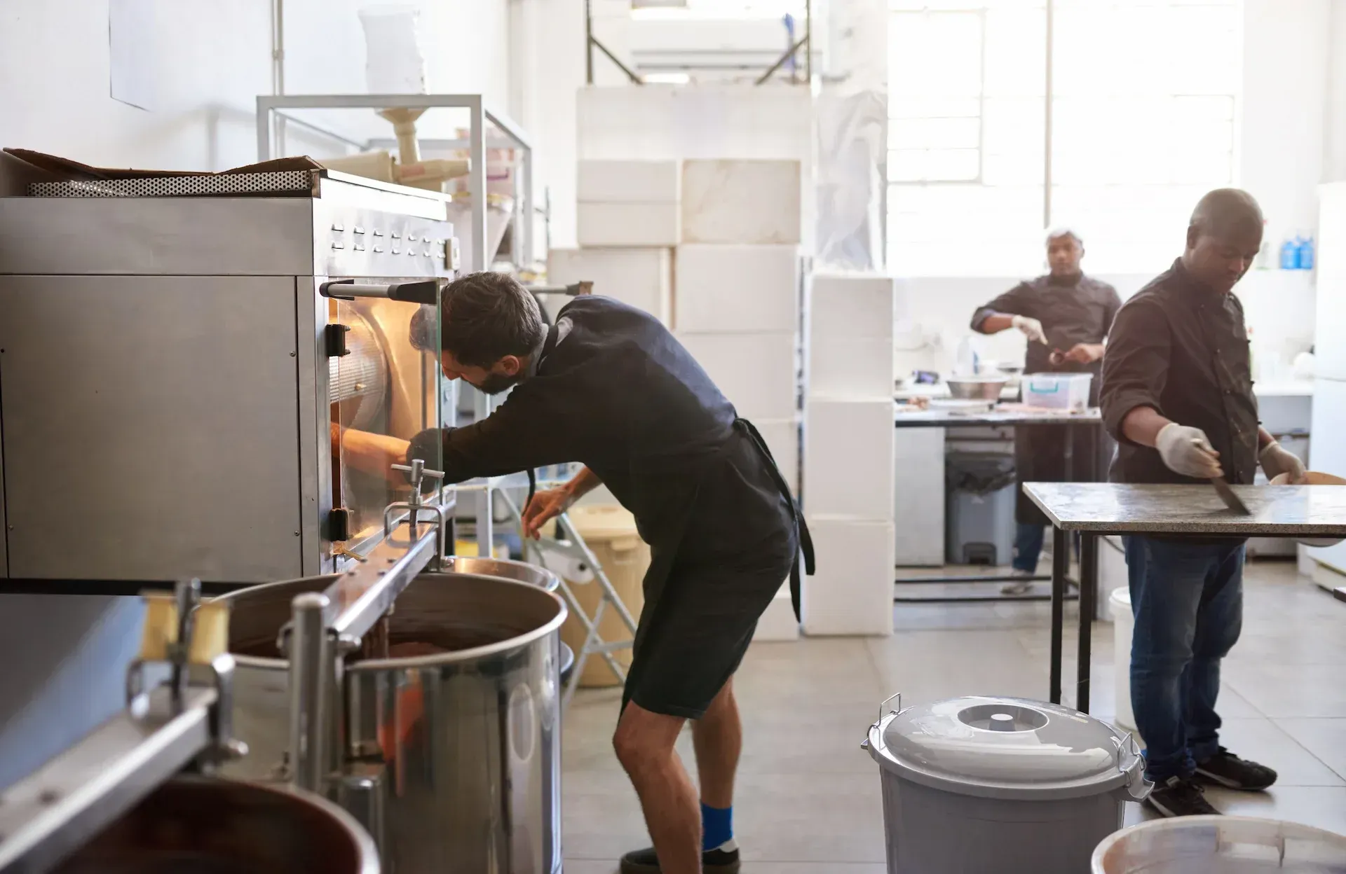 Bufé con exhibiciones de comida bajo brillantes lámparas de calor colgantes. Una persona está detrás del mostrador.