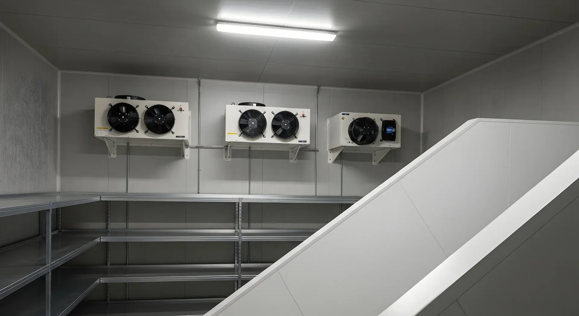 Bufé con exhibiciones de comida bajo brillantes lámparas de calor colgantes. Una persona está detrás del mostrador.