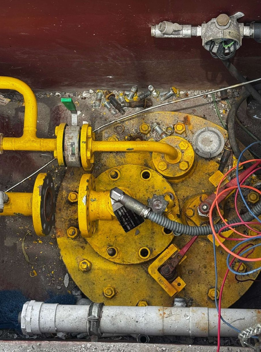 Cocina comercial de acero inoxidable brillante con planchas, electrodomésticos y campana extractora.