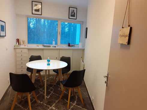 Une petite pièce avec une table et des chaises