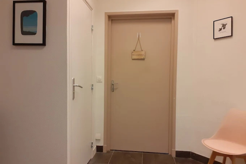 Un couloir avec une porte et une chaise dedans.