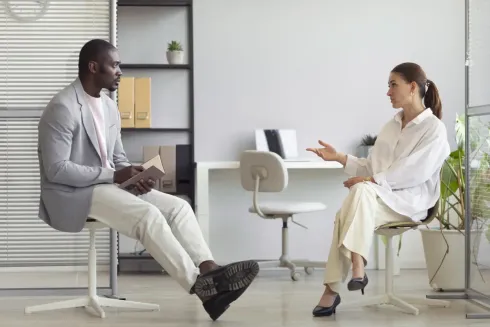 Un homme et une femme sont assis sur des chaises et discutent.