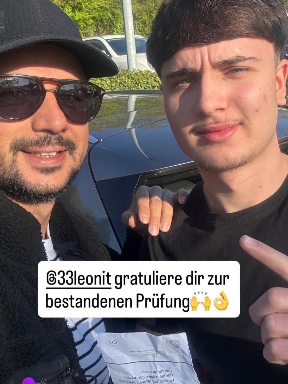 Personen machen draussen neben einem Auto ein Selfie, darüber wird ein Glückwunschtext in deutscher Sprache eingeblendet.
