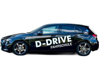 Schwarzer Fahrschulwagen mit D-DRIVE FAHRSCHULE-Logo an der Seite