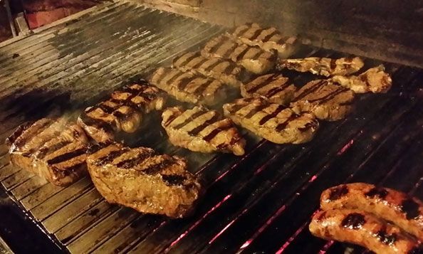Los filetes y las salchichas se cocinan en una parrilla