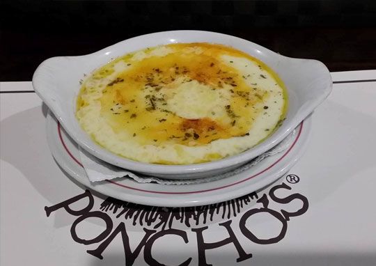 Un cuenco de comida reposa sobre el cartel de un poncho.