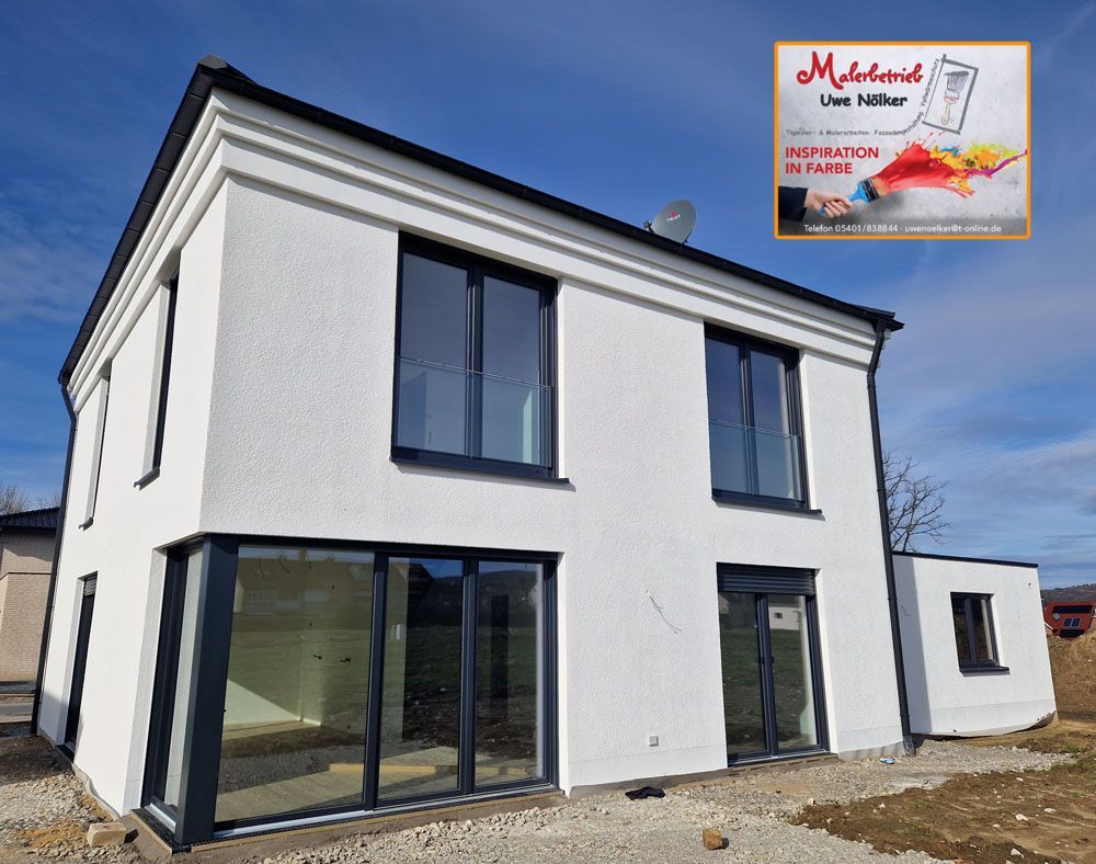 Ein Bild von einem weißen Haus mit schwarzen Fenstern und einem Schild mit der Aufschrift Malermeister