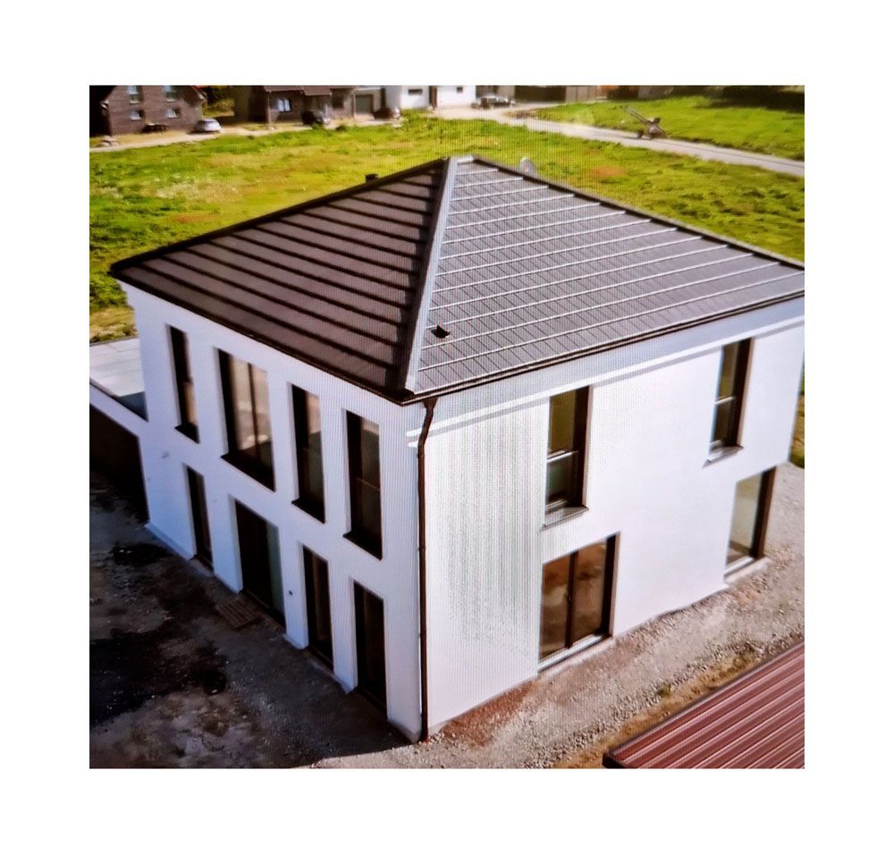 Eine Luftaufnahme eines weißen Hauses mit einem braunen Dach