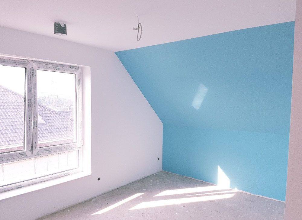 Ein leerer Raum mit einer blauen Wand und weißen Wänden