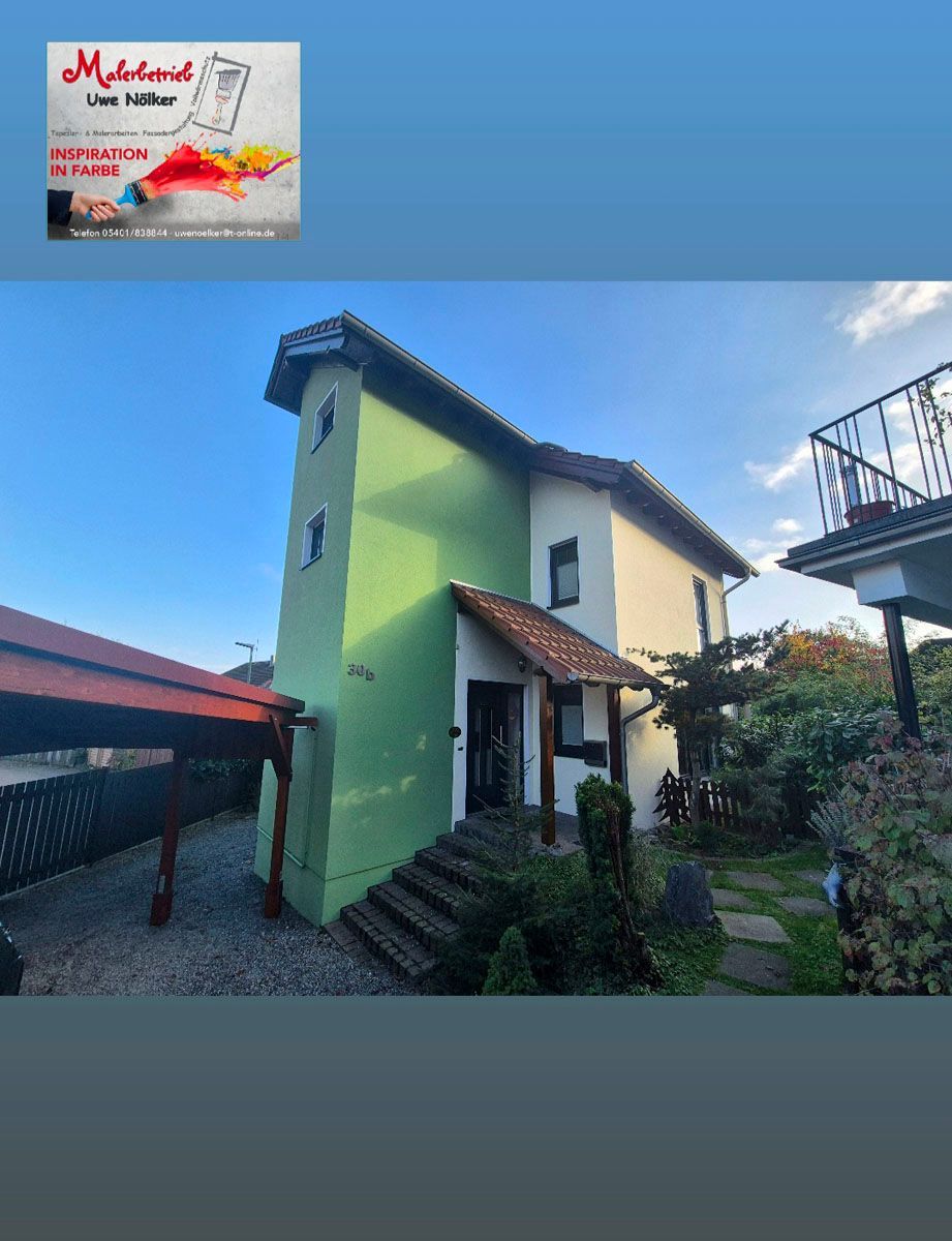 Ein Bild von einem grün-weißen Haus mit einem Schild darüber