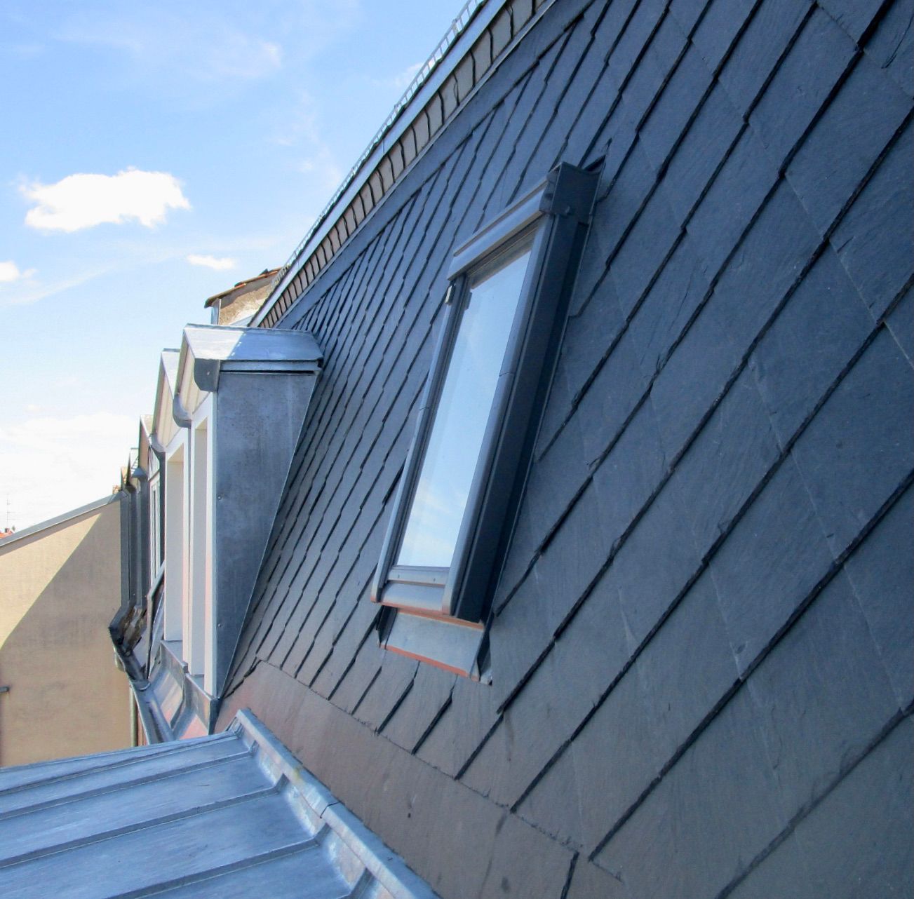 Stehfalz-Metalldach mit Dachfenstern und präziser Blechanschlussausführung.