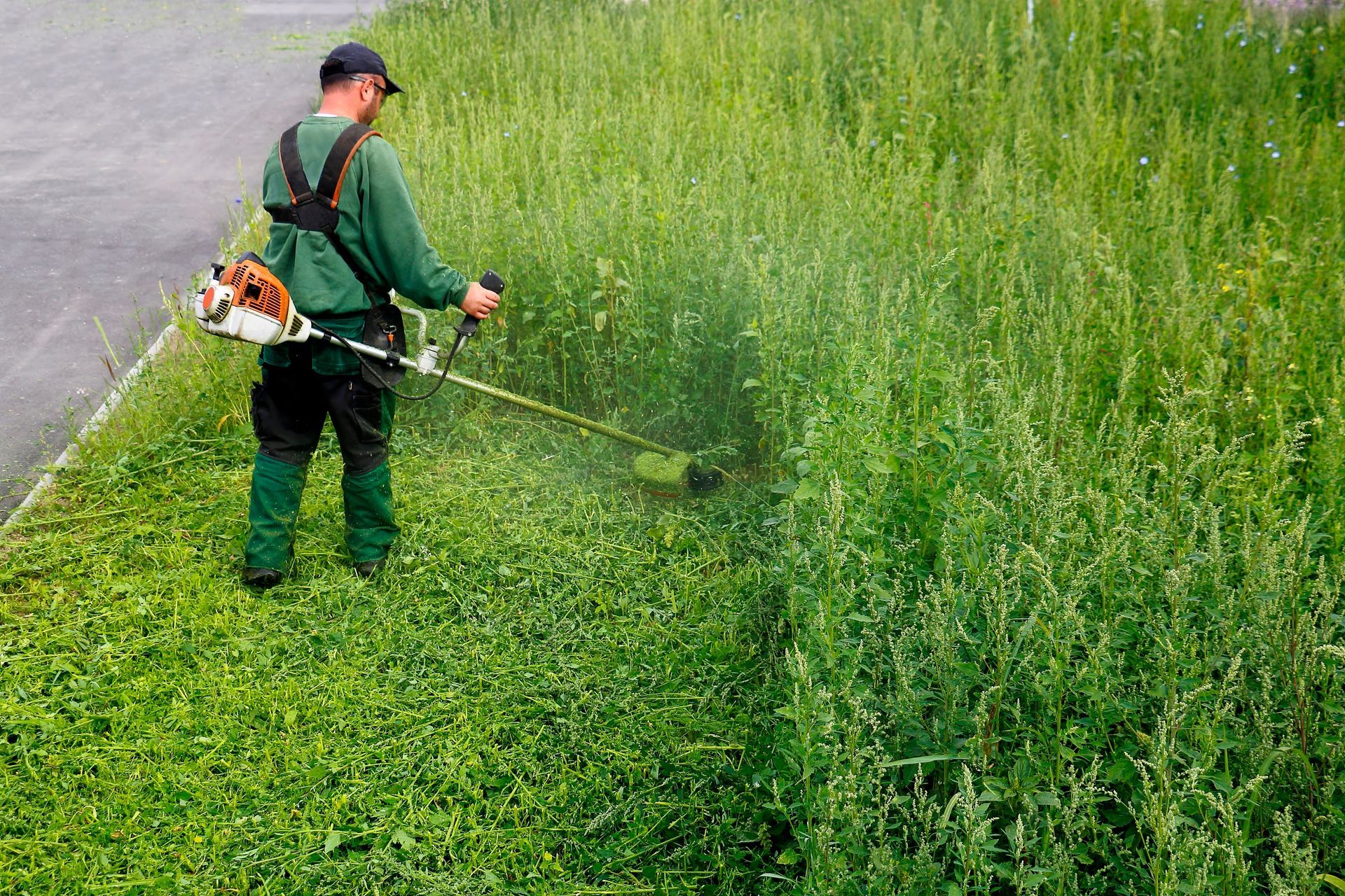 Ouvrier en train de débroussailler au rotofil