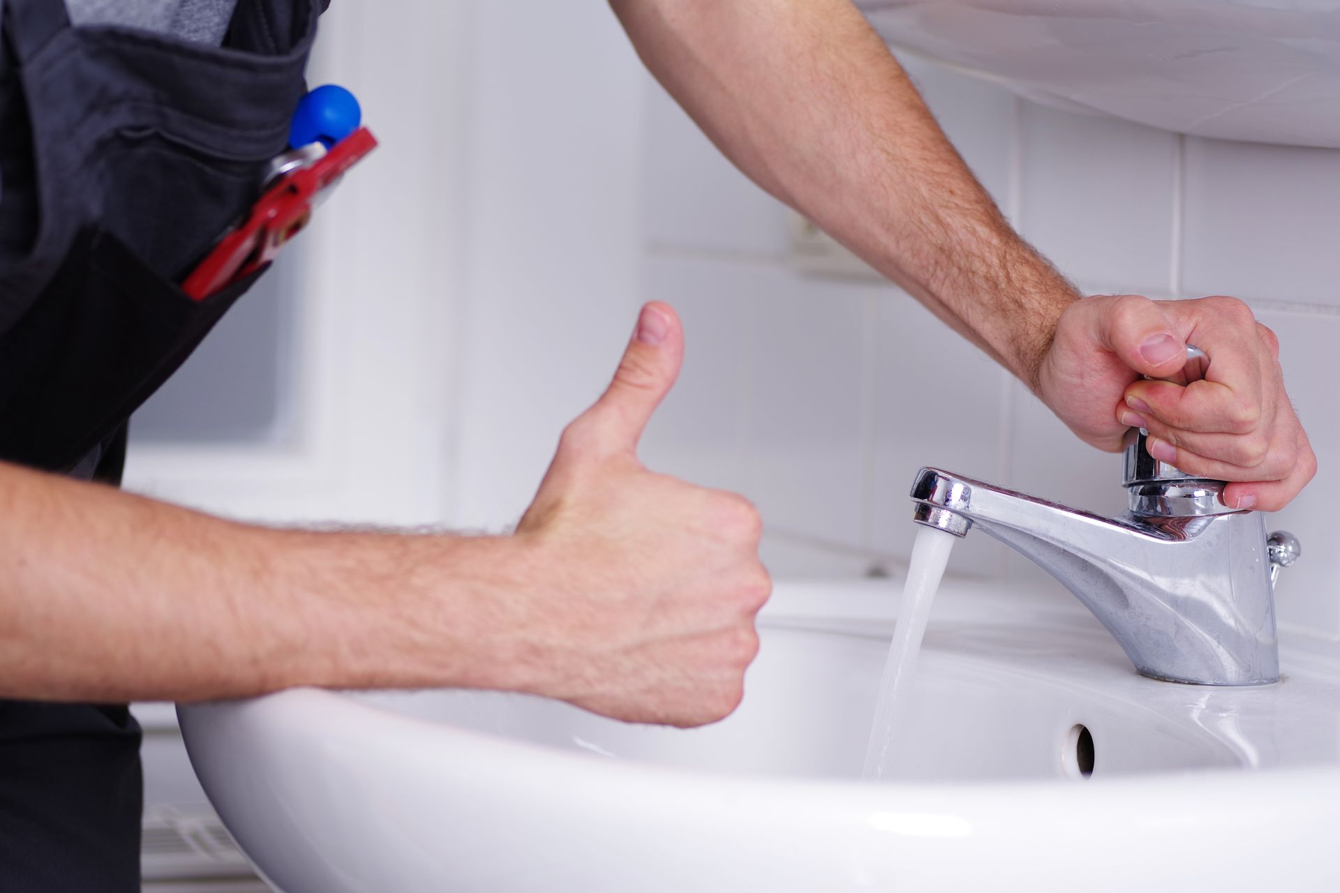 Profitarbeiter von A. Uhlich steht nach einer professionellen Rohrreinigung am Waschbecken