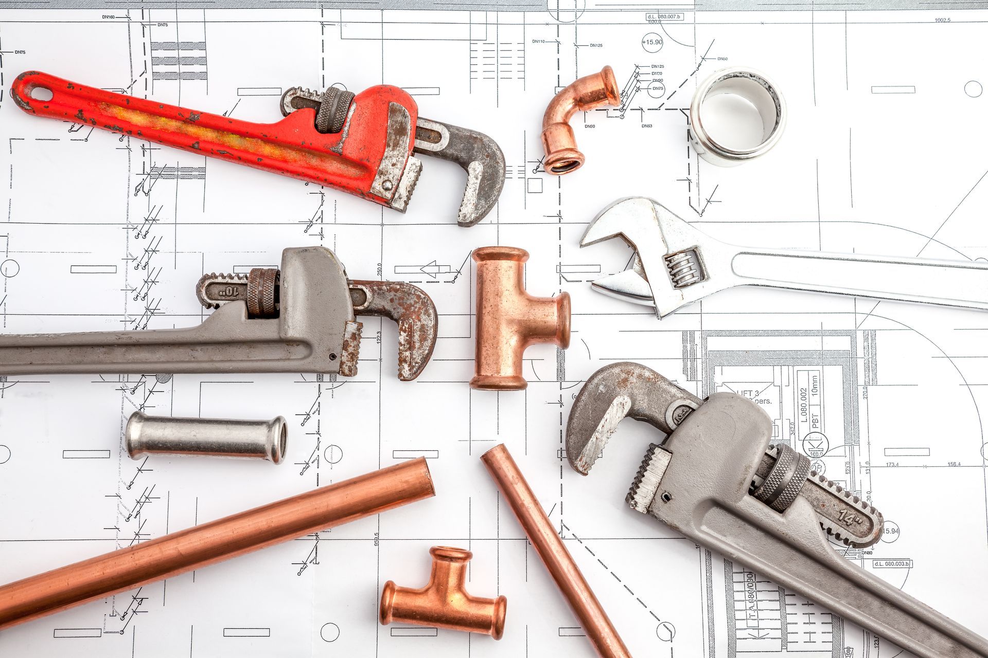 Werkzeuge zur Rohrsanierung liegen auf einer Skizze 