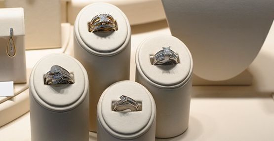 Anillos exhibidos en pedestales blancos en una joyería.