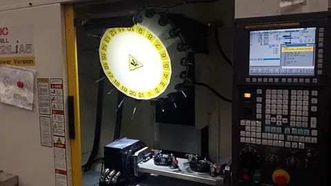 Una máquina está sentada en una habitación al lado de un monitor de computadora.