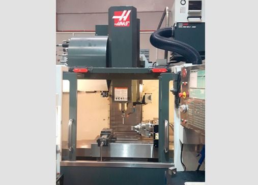 Una máquina Haas está en una habitación con una manguera conectada a ella.