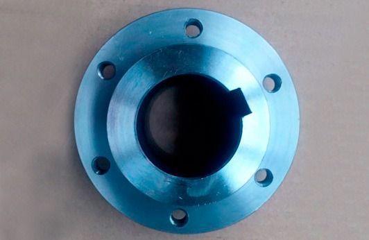 Un objeto de metal azul con agujeros está sobre una mesa.