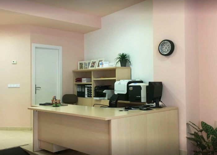 Una habitación con un escritorio y un reloj en la pared.