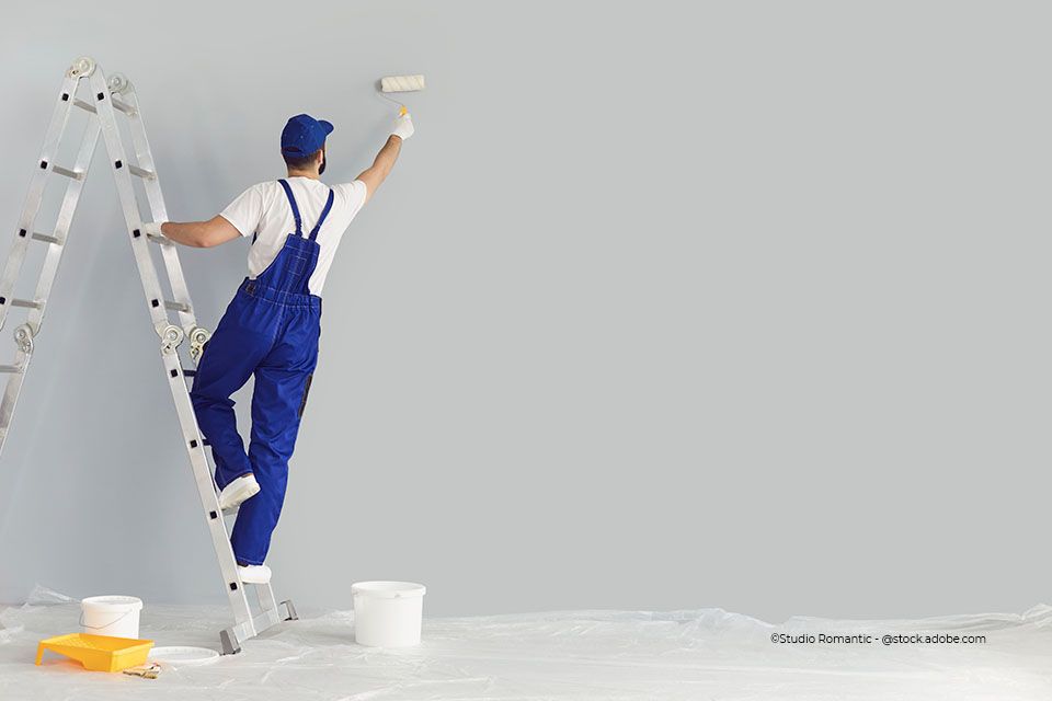 Mitarbeiter von Ausbau Fassaden Raumgestaltung Meisterbetrieb Alexander Linke steht auf einer Leiter und streicht eine Wand