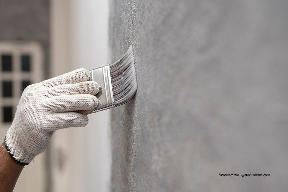 Mitarbeiter von Ausbau Fassaden Raumgestaltung Meisterbetrieb Alexander Linke streicht eine Wand mit einem Pinsel