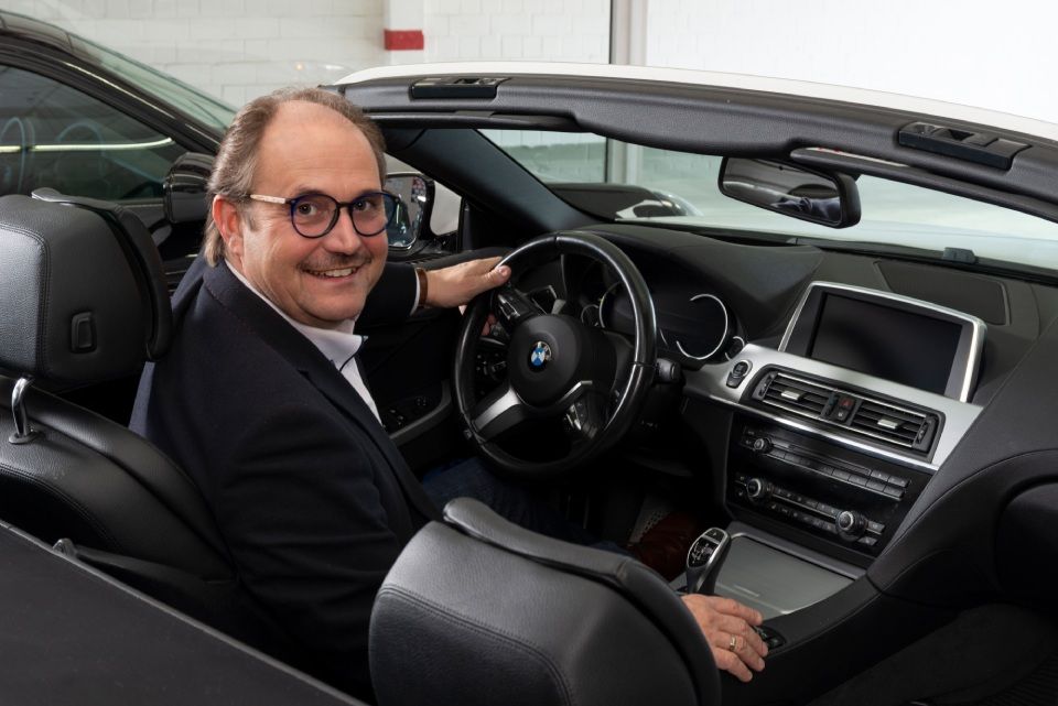 ächelnder Mann am Steuer eines Autos