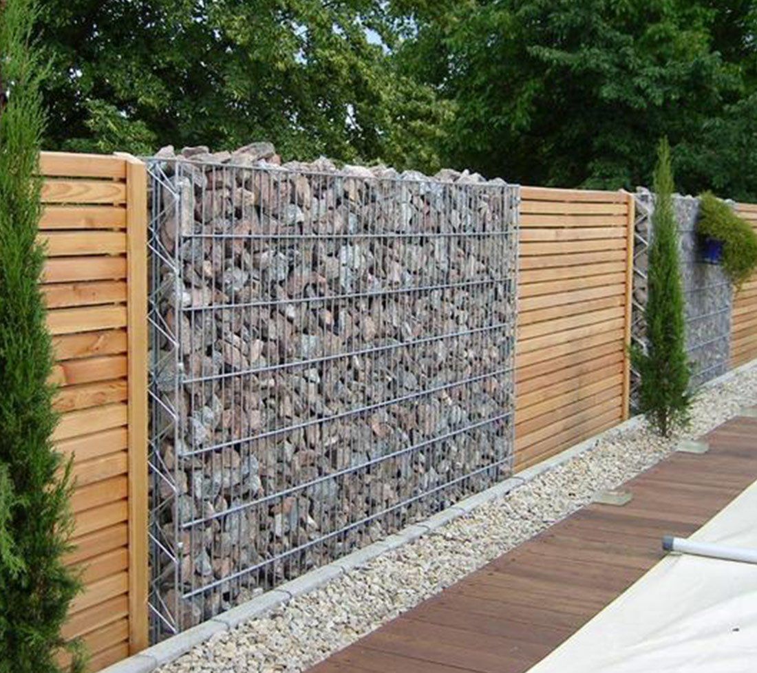 Muret en pierre entrecoupé de clôtures en bois