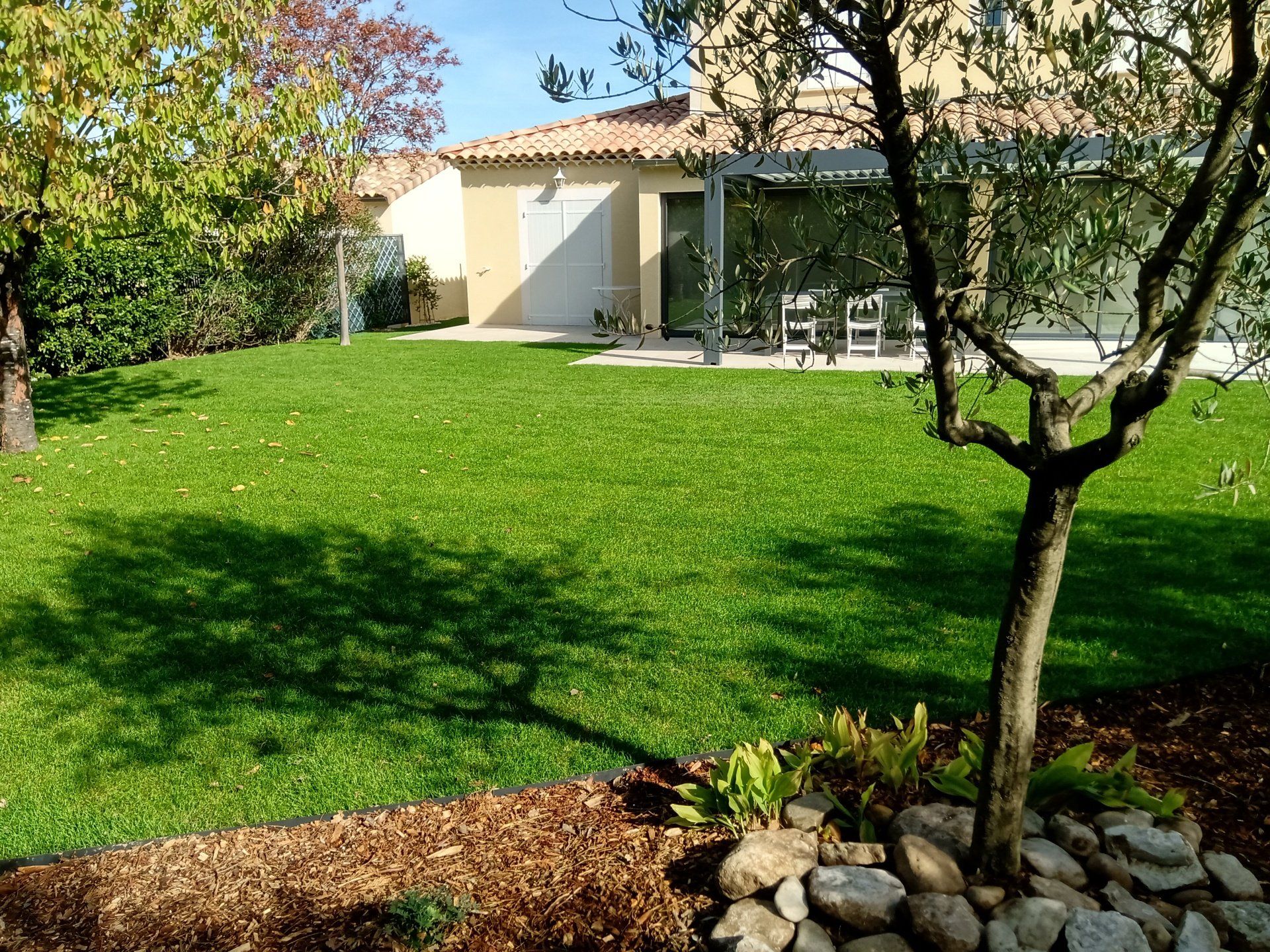 Terrain recouvert d'une pelouse verte en bordure d'une terrasse