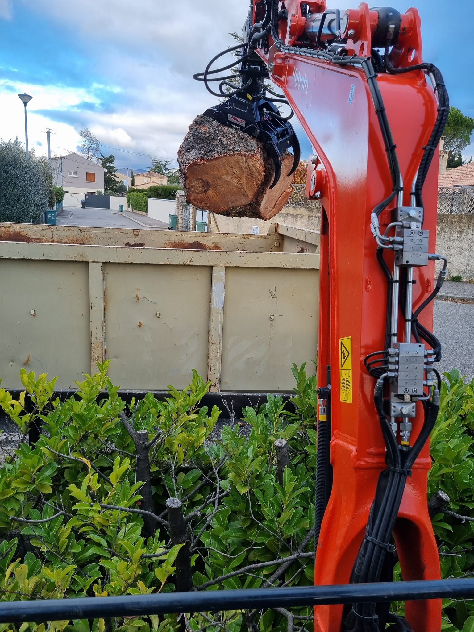 Pince mécanique portant un rondin de bois dans la benne d'un camion