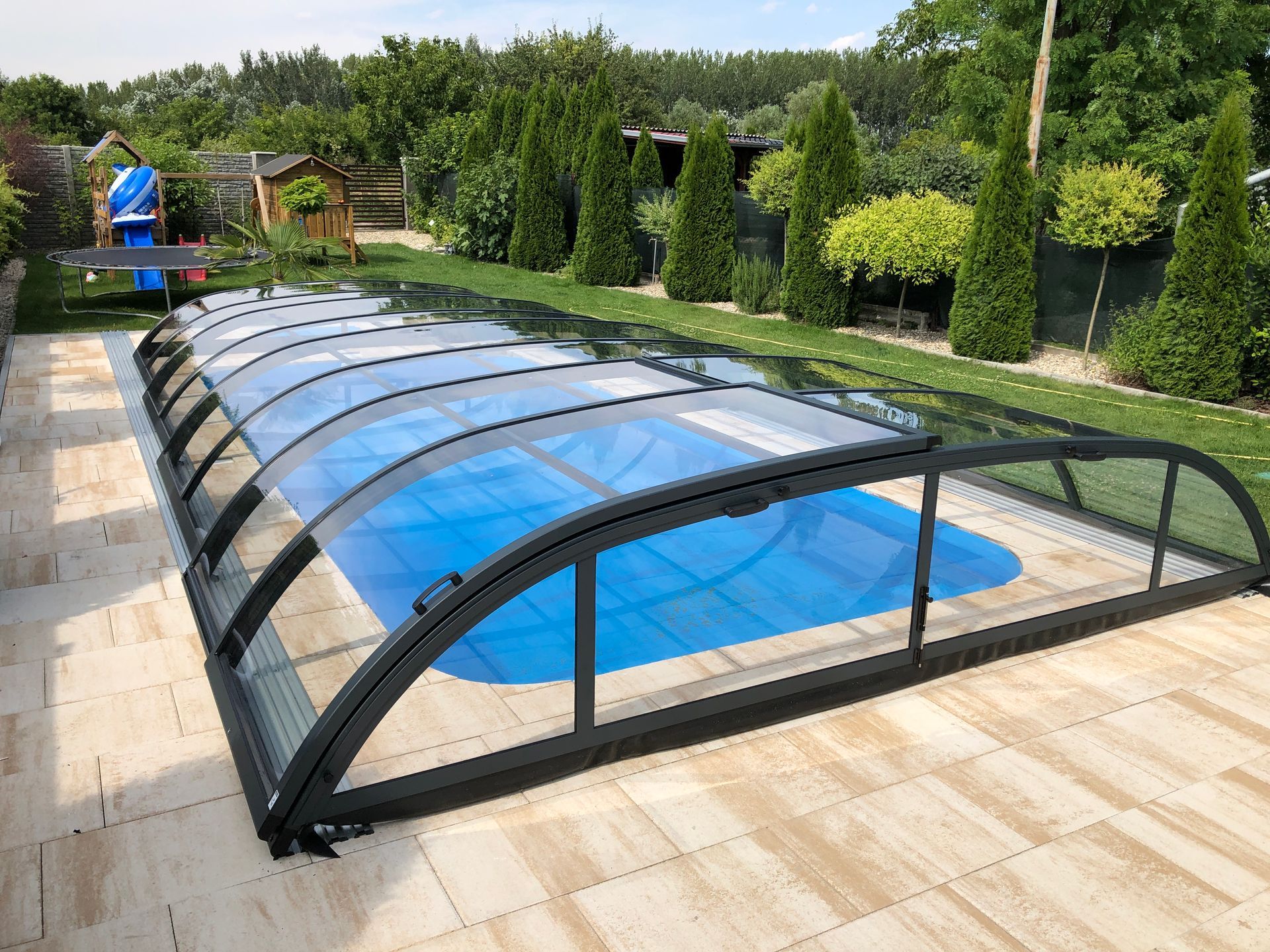 Abri en kit de piscine avec terrasse en carrelage