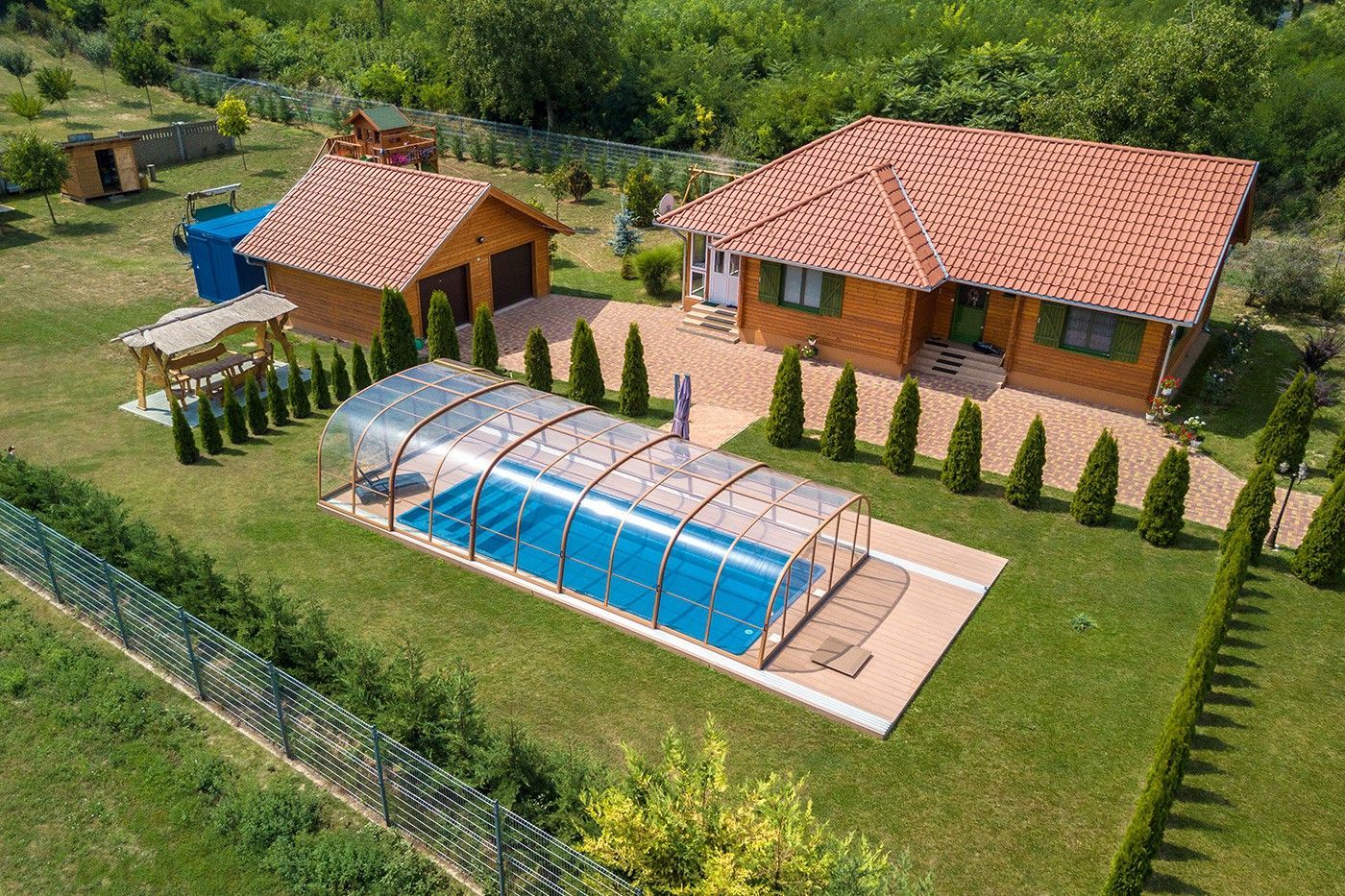 Abri de piscine dans le jardin d'une grande maison en bois