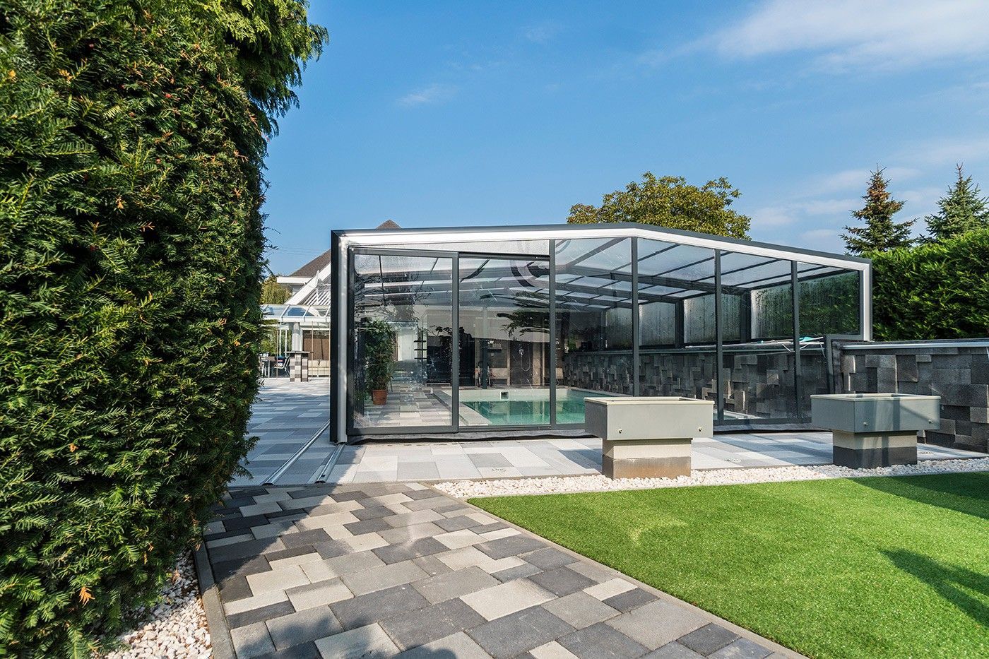 Abri de piscine sur une terrasse pavée