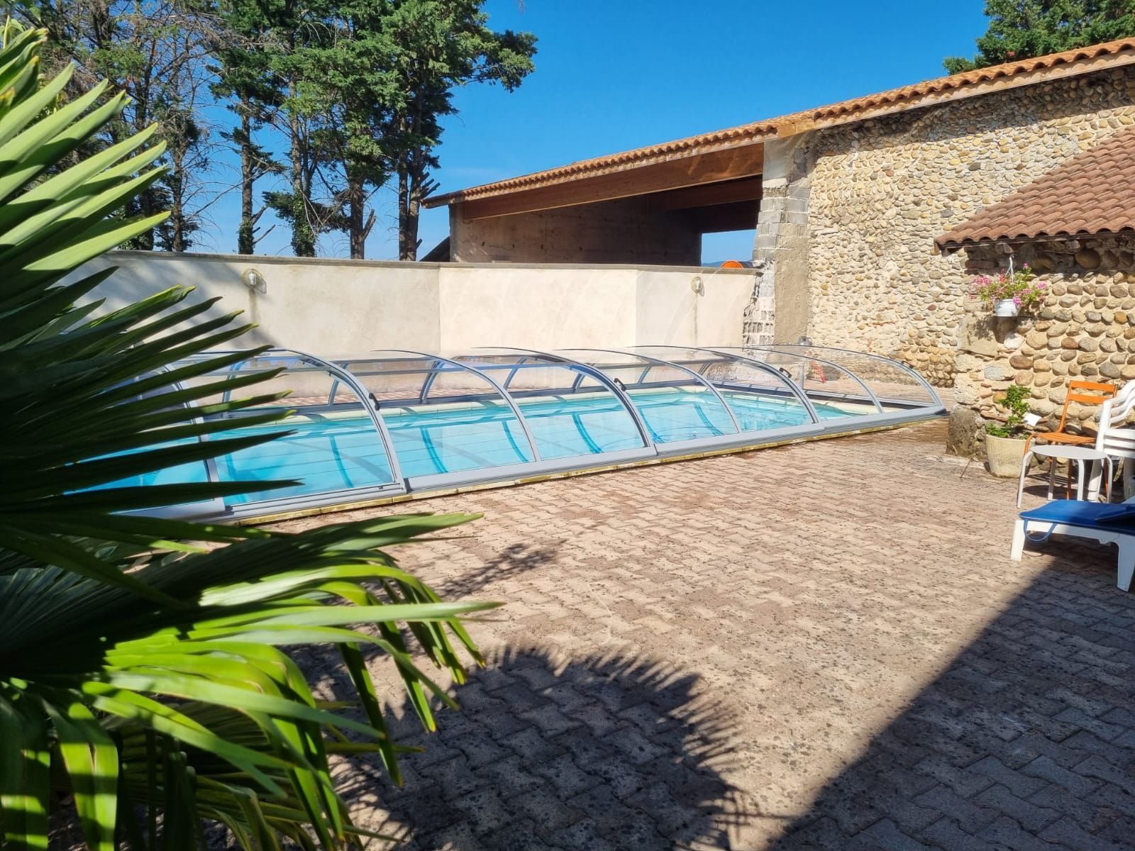 Abris de piscine dans la cour d'une maison en pierre