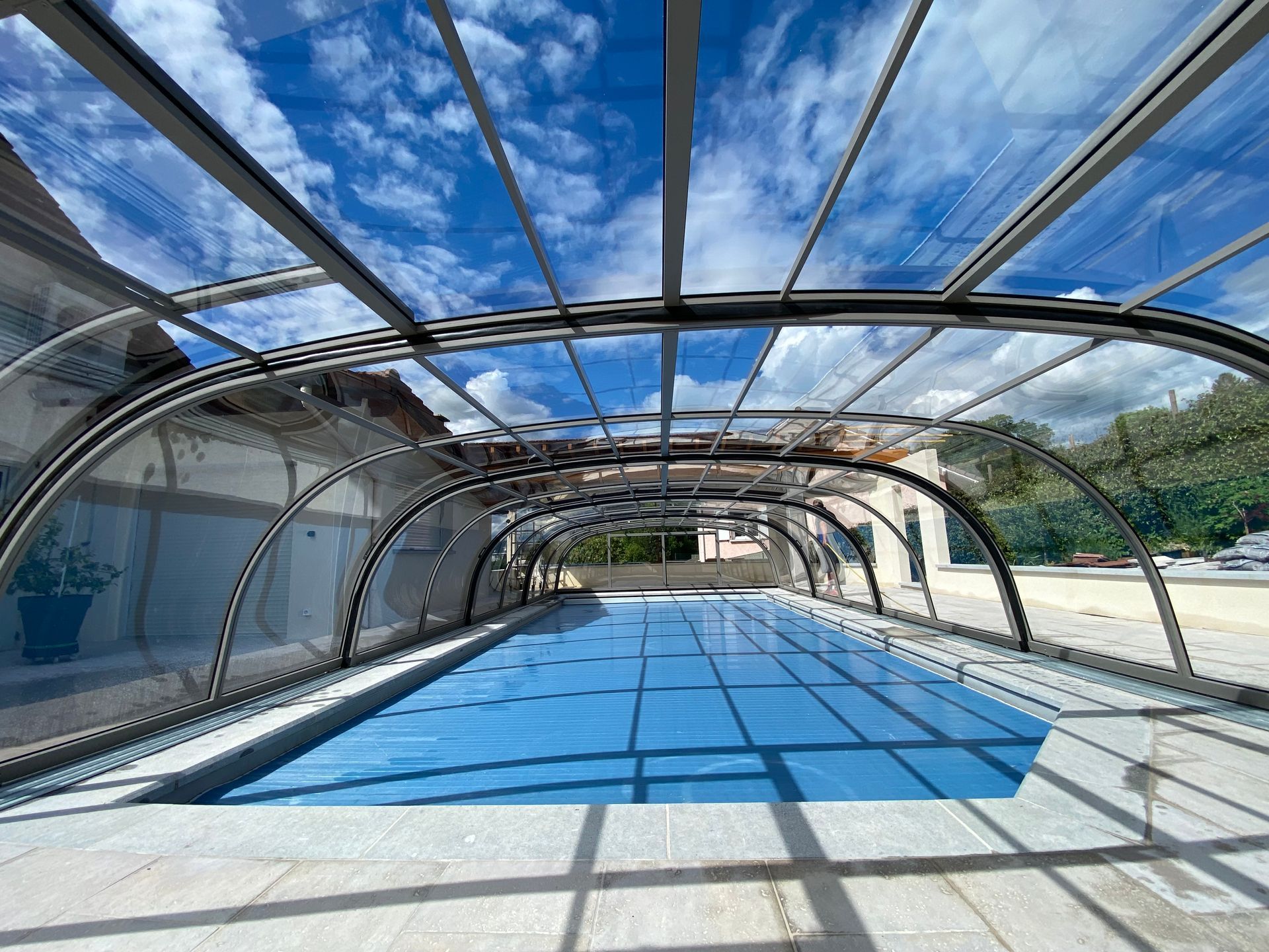 Abri de piscine vu de l'intérieur avec piscine bâchée