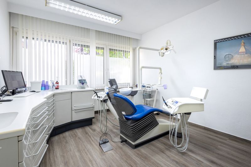 Ein Wartezimmer mit blauen Stühlen und Holzboden.