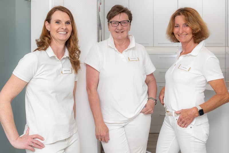 Zwei Frauen sitzen an einem Empfangstresen in einem Krankenhaus.