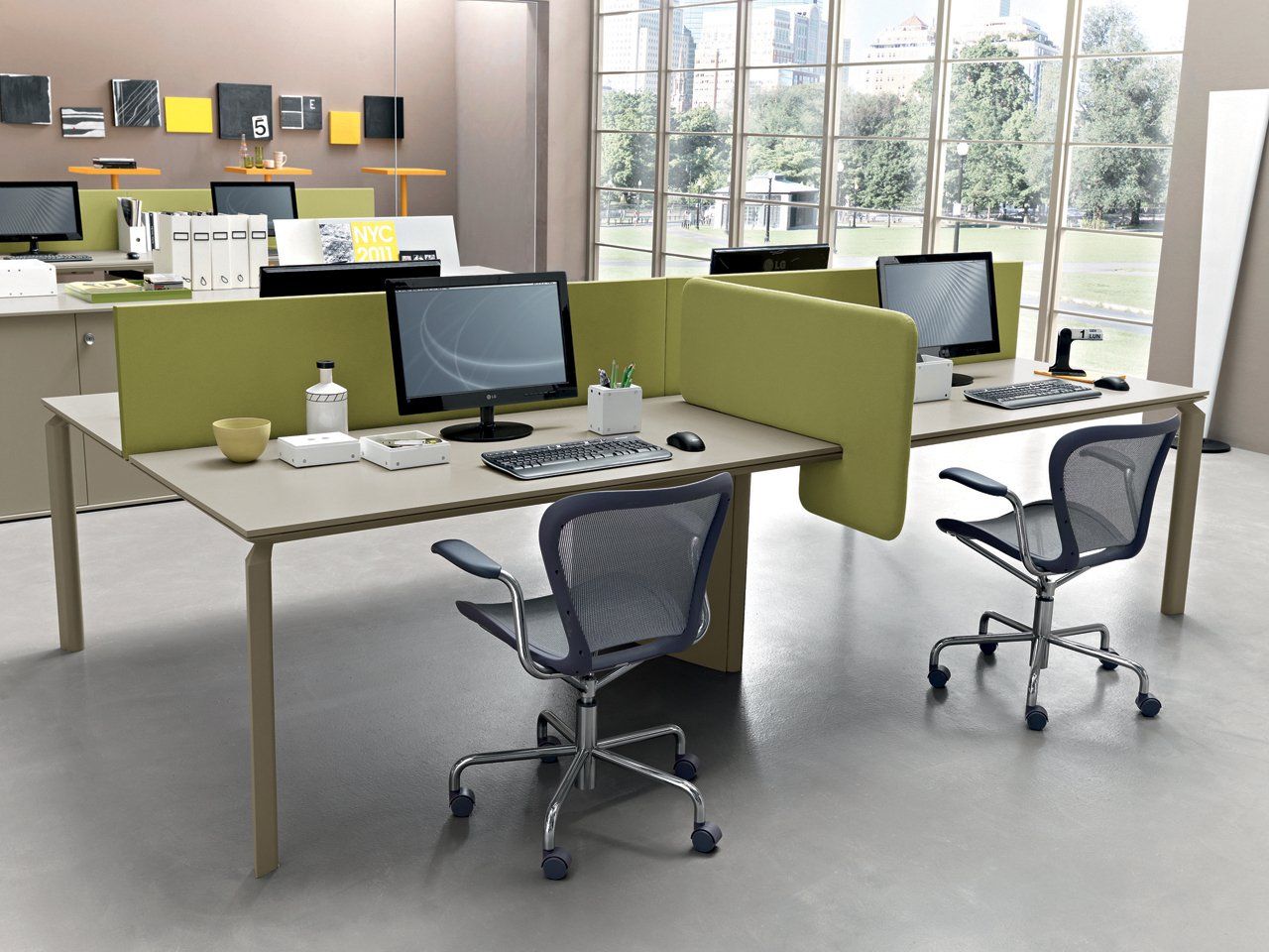 Bureau moderne avec deux postes de travail, chacun équipé d'un ordinateur, d'une chaise et d'une cloison ; tons clairs et neutres.