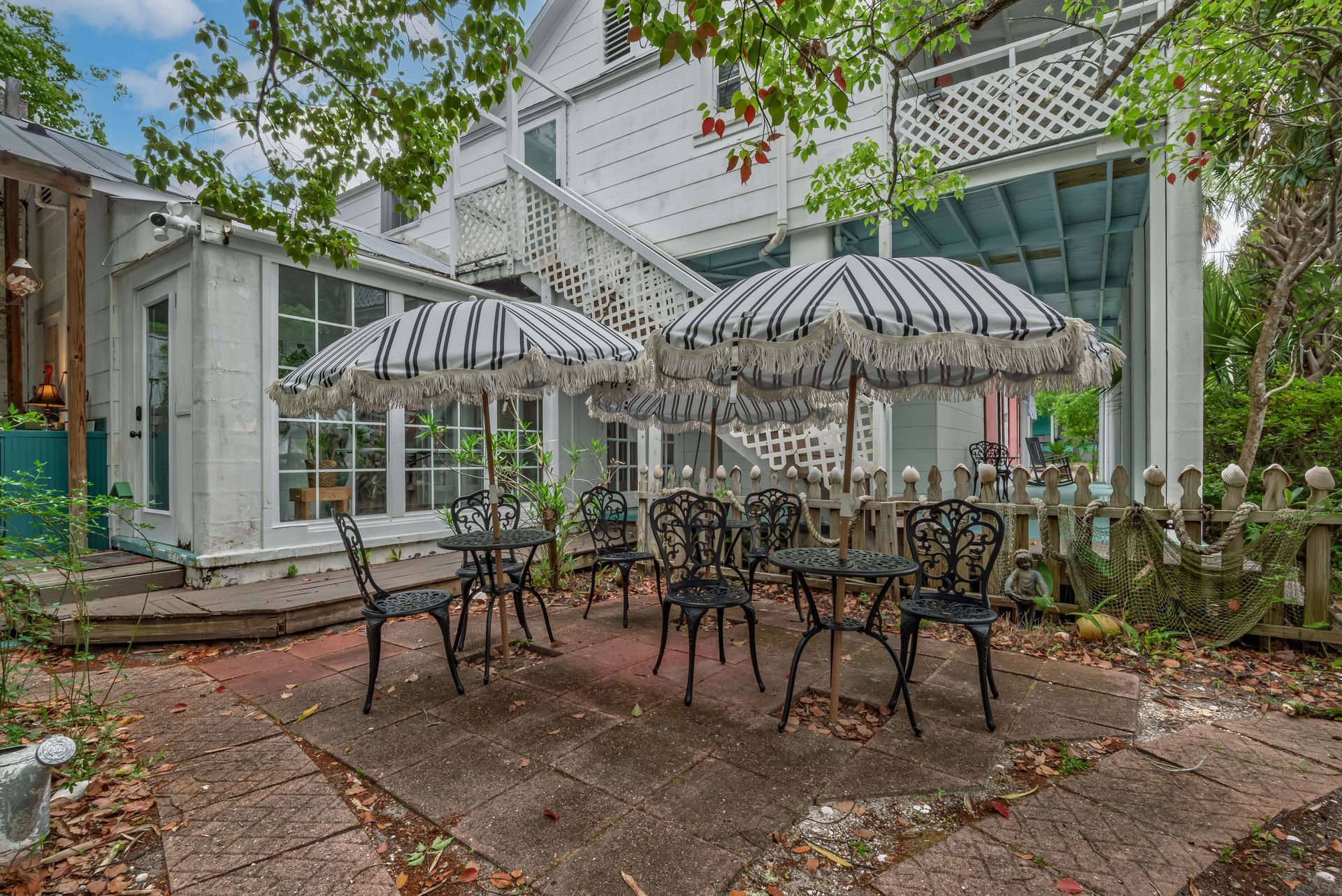 Outdoor patio with black metal tables, striped umbrellas private dining courtyard