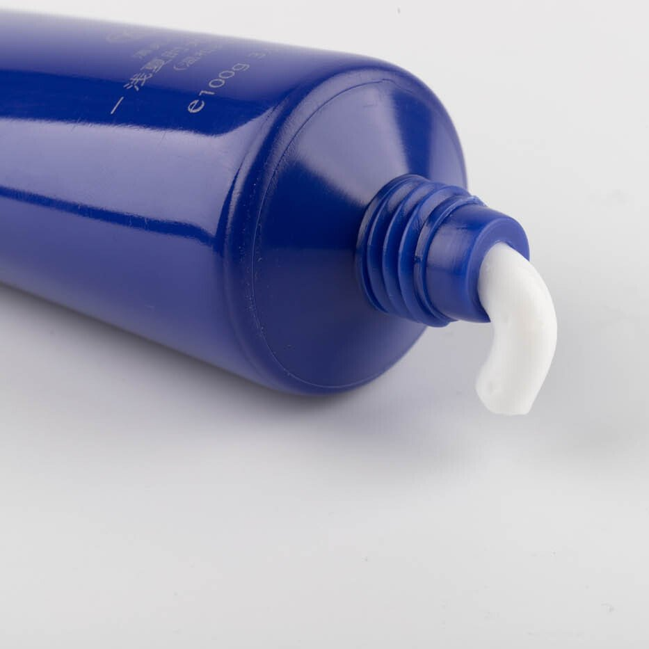 Dentifrice blanc avec le tube en plastique bleu
