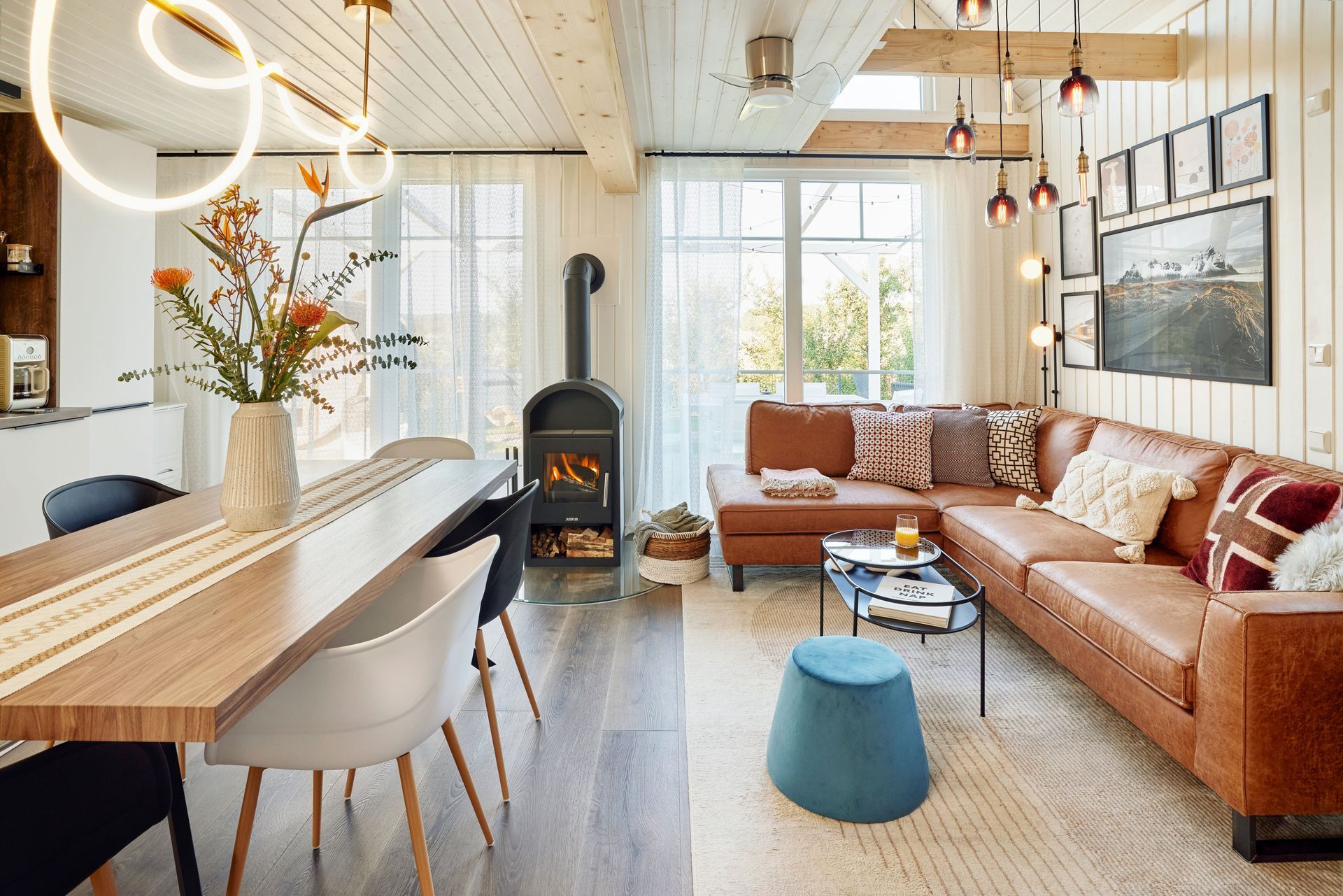 Living room with wood-burning stove, leather sofa and long dining table