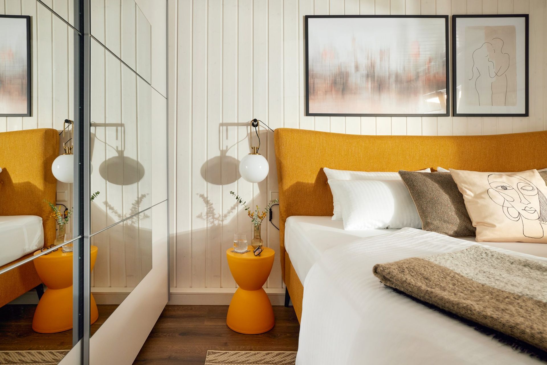 Bedroom with a mirrored wardrobe and a yellow headboard