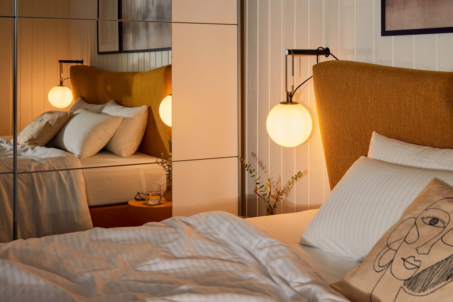 Bed with a warm bedside lamp and fresh linen