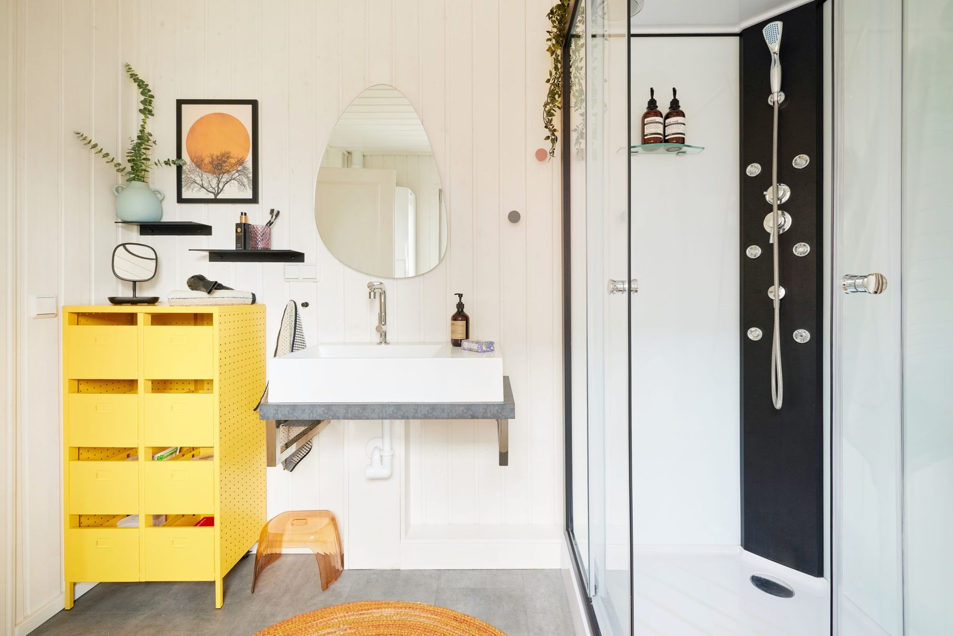 Bathroom with a yellow vanity and a round mirror