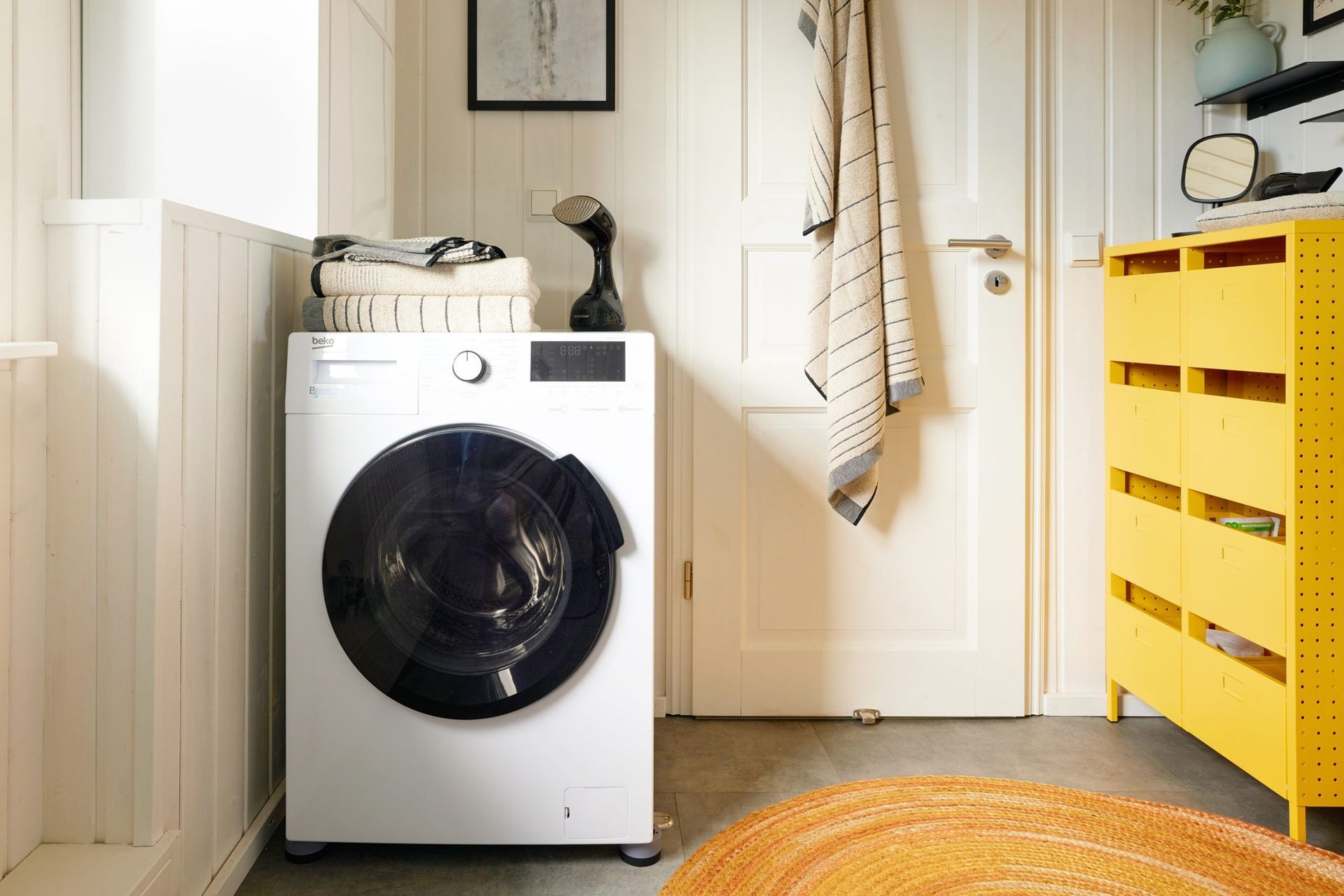 Washer-dryer and a yellow chest of drawers