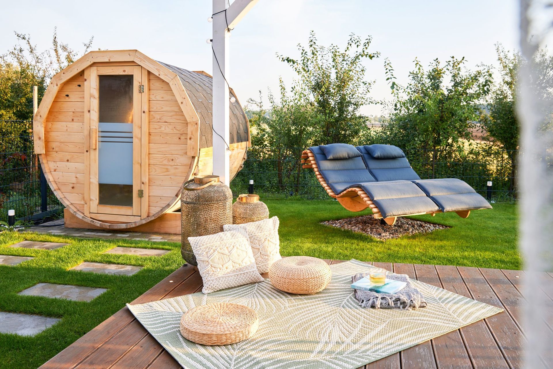 Barrel sauna and sun loungers in the fenced garden